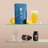 A supplement product display on two glass shelves against a warm beige background. The main item is a blue stand-up pouch labeled 'Calm' by Carlsberg, with two lemons, a glass of orange drink, and two black supplement bottles below.